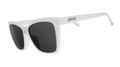 Three-quarter angle view of white angled cat-eye sunglasses with non-reflective black lenses.