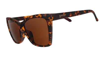 Three-quarter angle view of brown tortoiseshell angled cat-eye sunglasses with non-reflective brown lenses.