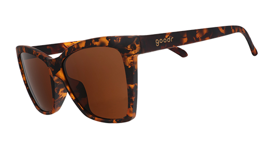 Three-quarter angle view of brown tortoiseshell angled cat-eye sunglasses with non-reflective brown lenses.